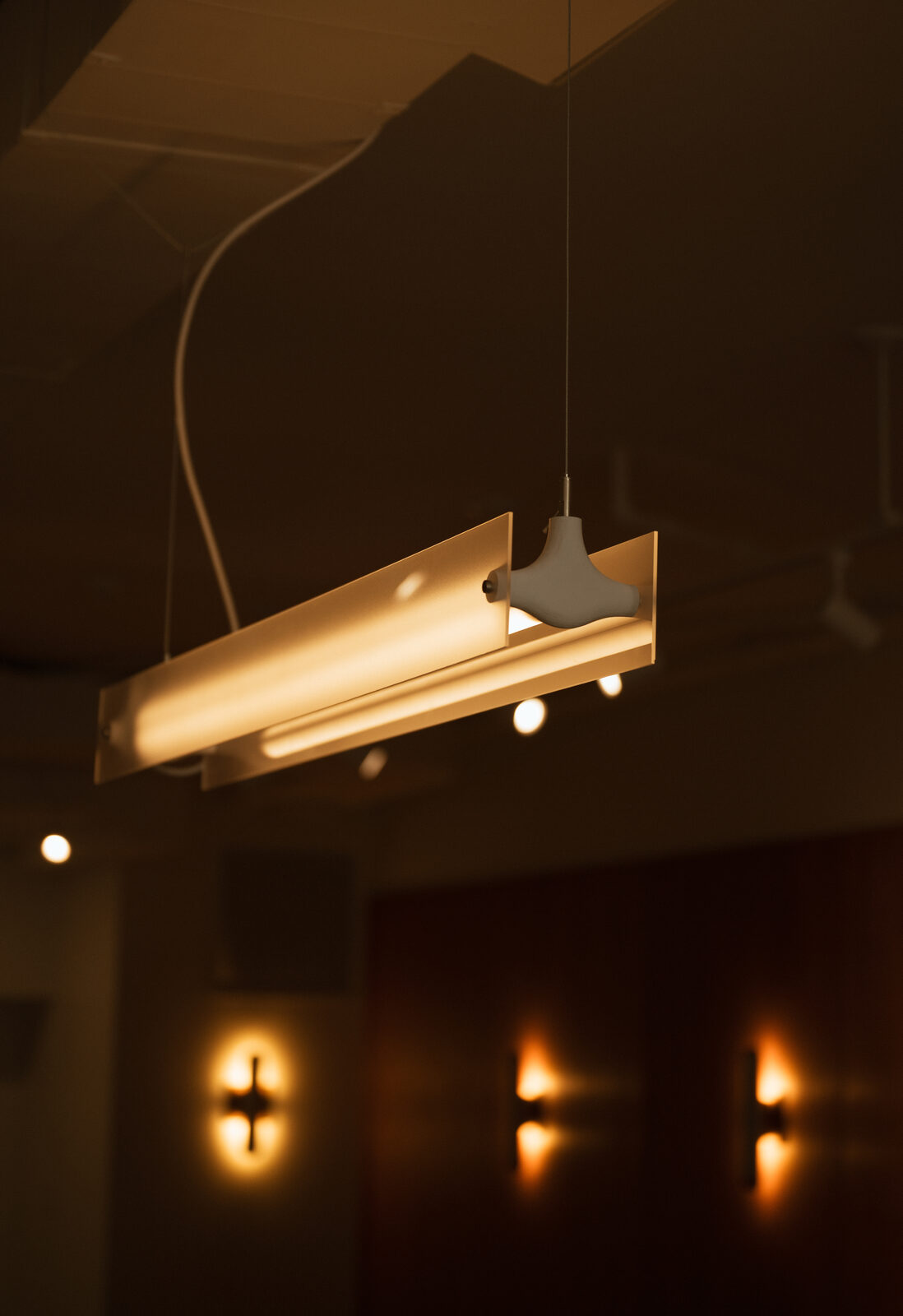 Custom linear pendant with aluminum extrusion and frosted acrylic diffuser above the coffee bar